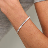Model wearing silver tennis bracelet. demi-fine diamond-look bracelet UK